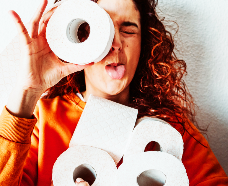 A woman peering through a roll of Regina and sticking out her tongue.